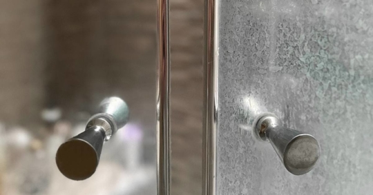 Glass shower doors with and without hard water marks
