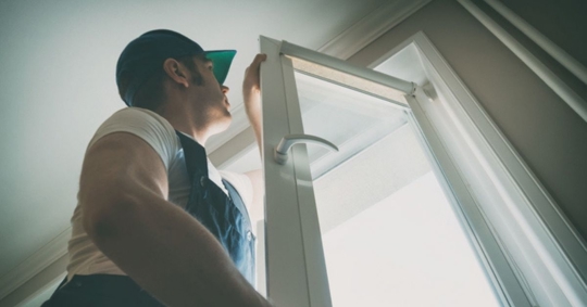 Professional handyman installing window at home